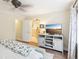 Bright bedroom with TV, adjoining bathroom, and light wood floors at 330 Woods Landing Trail, Oldsmar, FL 34677