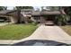Exterior view of townhome with a carport, lush lawn, and a deer in the yard at 330 Woods Landing Trail, Oldsmar, FL 34677