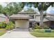 Exterior of well-maintained townhome featuring a carport, flag, and professional landscaping at 330 Woods Landing Trail, Oldsmar, FL 34677