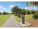 Scenic golf course pathway with landscaping, signage, and lush green grass on a sunny day at 330 Woods Landing Trail, Oldsmar, FL 34677