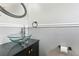 Stylish half bathroom featuring a unique glass bowl sink and modern fixtures at 330 Woods Landing Trail, Oldsmar, FL 34677