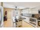 Kitchen boasts stainless steel appliances, white cabinets, a center island, and tile floors at 330 Woods Landing Trail, Oldsmar, FL 34677