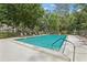 Community pool with lounge chairs and umbrella for relaxation at 330 Woods Landing Trail, Oldsmar, FL 34677