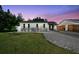 A well-kept single-story home with dark shutters and a clean driveway, enhanced by the beautiful dusk sky at 3315 W Pearl Ave, Tampa, FL 33611