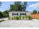 Charming home exterior with neatly trimmed bushes, gravel landscaping, and dark window shutters at 3315 W Pearl Ave, Tampa, FL 33611