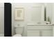 Well-lit bathroom features a sleek vanity, toilet, and a shower with a dark shower curtain at 3469 Lapis Lake Dr, Zephyrhills, FL 33541