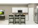 Modern kitchen with stainless steel appliances, white cabinets, and a functional breakfast bar at 3469 Lapis Lake Dr, Zephyrhills, FL 33541