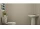 Minimalist powder room features a toilet and pedestal sink, perfect for guests at 3469 Lapis Lake Dr, Zephyrhills, FL 33541
