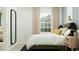 Bright bedroom featuring a large window, a bed, and a full-length mirror at 3477 Lapis Lake Dr, Zephyrhills, FL 33541