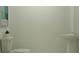A powder room featuring a toilet and wash basin in a minimalistic setting at 3477 Lapis Lake Dr, Zephyrhills, FL 33541