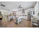 Open kitchen featuring white cabinets, stainless steel appliances, large island with counter seating and light wood floors at 3543 Gamble St, New Port Richey, FL 34655