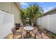 Private courtyard patio featuring a table and chairs, a white fence, and tropical landscaping at 3543 Gamble St, New Port Richey, FL 34655