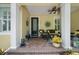 Inviting front porch with comfortable seating, ceiling fan, and brick flooring at 3543 Gamble St, New Port Richey, FL 34655