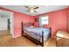Bedroom features coral walls, wood floors, one window, and an overhead fan at 3621 Beacon Square Dr, Holiday, FL 34691