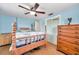 Bedroom features light blue walls, wood floors, closet, dresser and a wood frame bed at 3621 Beacon Square Dr, Holiday, FL 34691