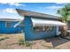 Angle view of the house featuring blue siding, an awning, and a window at 3621 Beacon Square Dr, Holiday, FL 34691