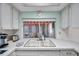 Classic kitchen featuring a dual-basin sink, white cabinets, and view to outdoor patio at 3621 Beacon Square Dr, Holiday, FL 34691