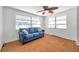 Inviting living room with wood-look floors, ceiling fan, and abundant natural light at 3621 Beacon Square Dr, Holiday, FL 34691