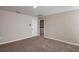 Comfortable bedroom with plush carpeting, neutral colors, and a laundry area viewable through the door at 37114 Sagemoor Dr, Zephyrhills, FL 33541