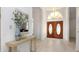 Bright foyer with wood-look tile floors, stylish console table, and decorative double doors at 3908 Lithia Ridge Blvd, Valrico, FL 33596