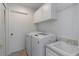 Functional laundry room with modern washer, dryer, sink, and cabinet storage at 3908 Lithia Ridge Blvd, Valrico, FL 33596