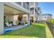 Backyard featuring a lawn, patio with modern furniture, and views of the condo complex at 4357 Marina View Way, Cortez, FL 34215