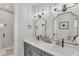 Bright bathroom featuring double sinks, modern fixtures, and decorative mirrors and sconces at 4357 Marina View Way, Cortez, FL 34215