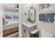 Modern bathroom boasts a vanity with a framed mirror, decorative lighting, and white marble countertops at 4357 Marina View Way, Cortez, FL 34215