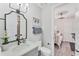 The cozy bathroom includes a gray vanity and a framed mirror with decorative palm tree art at 4357 Marina View Way, Cortez, FL 34215