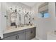 Bright bathroom featuring double sinks, modern fixtures, and decorative mirrors and sconces at 4357 Marina View Way, Cortez, FL 34215
