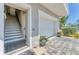 Close-up view of a home's exterior, showcasing the garage door and a staircase entrance nearby at 4357 Marina View Way, Cortez, FL 34215