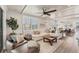 Bright open-concept living room with wood floors, plantation shutters, and comfortable seating at 4357 Marina View Way, Cortez, FL 34215