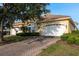 Charming yellow home featuring a brick driveway, a well-kept lawn and manicured landscaping at 4605 Casswell Dr, New Port Richey, FL 34652
