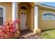 A charming white front door framed by columns and complemented by vibrant landscaping at 4605 Casswell Dr, New Port Richey, FL 34652