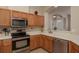 Kitchen with stainless steel appliances, light wood cabinets, and a convenient breakfast bar overlooking the entryway at 4605 Casswell Dr, New Port Richey, FL 34652