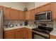 Kitchen featuring stainless steel appliances, wood cabinets, a breakfast bar, and tile backsplash at 4605 Casswell Dr, New Port Richey, FL 34652