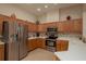 Modern kitchen featuring stainless steel appliances, wood cabinets, tile backsplash, and ample countertop space at 4605 Casswell Dr, New Port Richey, FL 34652