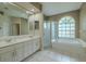 Large bathroom featuring double vanity, soaking tub, and walk-in shower at 4612 River Overlook Dr, Valrico, FL 33596