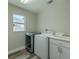 Laundry room featuring a washer, dryer, utility sink, window, and vinyl floor at 4612 River Overlook Dr, Valrico, FL 33596
