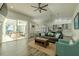 Bright living room with ceiling fan, plush seating, and sliding glass doors to an outdoor patio with water view at 4612 River Overlook Dr, Valrico, FL 33596