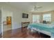 Comfortable main bedroom with hardwood floors, ceiling fan, and view to en-suite and water views at 4612 River Overlook Dr, Valrico, FL 33596