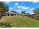 Fenced in back yard with a large grass area, mature trees and an enclosed pool at 490 Knight Dr, Tarpon Springs, FL 34688