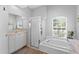 Bright bathroom with a walk-in shower, a soaking tub, and a sunny window at 490 Knight Dr, Tarpon Springs, FL 34688
