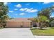 Charming single-story home featuring a well-manicured lawn, mature trees, and a three-car garage at 490 Knight Dr, Tarpon Springs, FL 34688