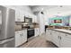 Bright kitchen with white cabinets, stainless steel appliances, and a view to a lovely living area at 490 Knight Dr, Tarpon Springs, FL 34688