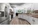 Modern kitchen with white cabinetry, stainless steel appliances, and a seamless view into the living area at 490 Knight Dr, Tarpon Springs, FL 34688