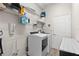 Bright laundry room with modern washer and dryer, wire shelving and laminate countertops at 490 Knight Dr, Tarpon Springs, FL 34688