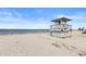 Lifeguard station on a sandy beach with calm ocean and clear blue sky at 490 Knight Dr, Tarpon Springs, FL 34688