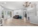 Open living room showcasing wood floors, neutral paint, modern chandelier, and sliding doors to pool at 490 Knight Dr, Tarpon Springs, FL 34688