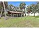 Open-air park pavilion with picnic tables, surrounded by lush green grass and mature trees at 490 Knight Dr, Tarpon Springs, FL 34688
